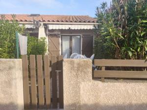 une clôture en bois devant une maison dans l'établissement Maison climatisée dans résidence avec piscine, à Saint-Cyprien