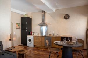 a kitchen with a table and a stove top oven at Cepoun - Grand studio centre Saint-Tropez in Saint-Tropez