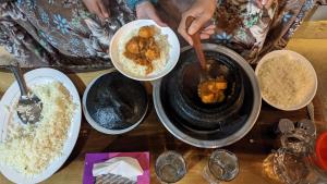 a table topped with bowls of food and rice at COSY STONES bY MANOKUR-E- BASA in Minapin