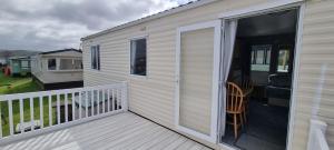 Mobilheim mit einer Terrasse mit Glasschiebetür in der Unterkunft Seaside View Holiday Home in Aberystwyth