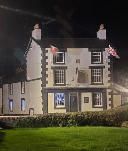 una gran casa blanca con una bandera americana delante de ella en Prince of wales accommodation, en Llangollen