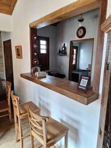 cocina con barra con mesa y sillas en Casa da Estação: seu refúgio à beira dos trilhos en Tiradentes