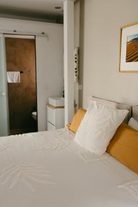 Una cama con sábanas blancas y almohadas en un dormitorio en Casa Africa, en Tarifa