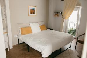 a bed with white sheets and orange pillows in a bedroom at Casa Africa in Tarifa