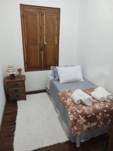 1 dormitorio con 1 cama y armario de madera en Casa da Estação: seu refúgio à beira dos trilhos en Tiradentes