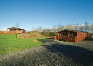 una baita di tronchi con portico e una casa di Nunland Hillside Lodges a Holywood