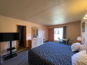 サン・トゥスタッシュにあるMotel St-Eustacheのベッドとテレビが備わるホテルルームです。