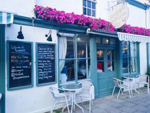 a restaurant with tables and chairs in front of a building at Noble Goose Rooms in Coggeshall