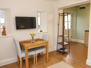 een eetkamer met een tafel en stoelen en een televisie bij Woodland View in Bishop Auckland