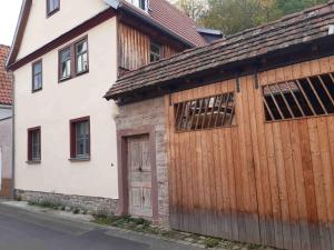 um edifício branco com uma garagem de madeira em Ferienhaus an der Höh' em Zellingen