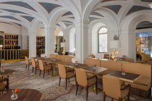 un restaurante con mesas, sillas y techos en Maison Roma Piazza di Spagna UNA Esperienze en Roma