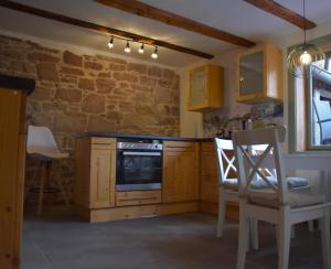 uma cozinha com armários de madeira e uma parede de pedra em Ferienhaus an der Höh' em Zellingen