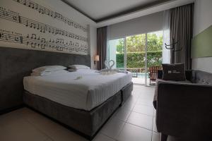 a bedroom with a bed with musical notes on the wall at The Melody Phuket - SHA Extra Plus in Kata Beach