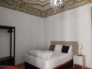 a bedroom with a white bed with a ceiling at Grand Via House in Madrid