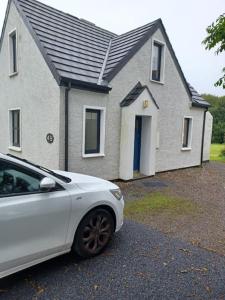 a white car parked in front of a house at Clifden Glen Cottage in Clifden