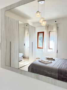 una camera con un grande specchio e un letto di Come a Casa Tua a Sassari