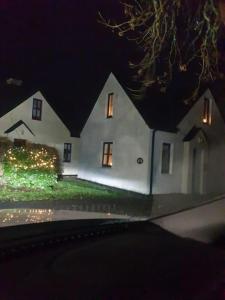 a white house with christmas lights in front of it at Clifden Glen Cottage in Clifden