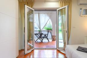 1 dormitorio con puertas correderas que dan a un patio en ROMA - Bel Poggio Country House, en Roma