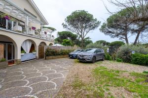 zwei Autos, die vor einem Haus geparkt sind in der Unterkunft ROMA - Bel Poggio Country House in Rom