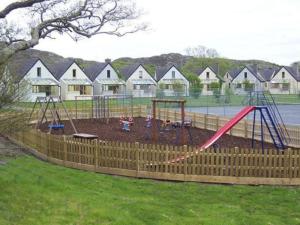 a playground with a swing set in a yard at Clifden Glen Cottage in Clifden