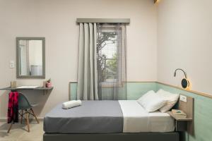 um quarto com uma cama, uma secretária e uma janela em Stefanie Studios em Agia Marina Nea Kydonias
