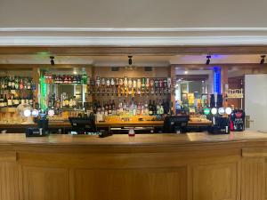 a bar with a lot of bottles of alcohol at Airport Inn Manchester in Wilmslow