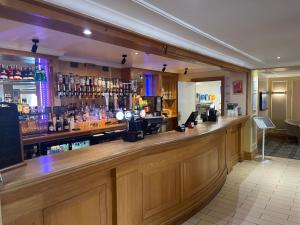 a bar in a pub with a wooden counter at Airport Inn Manchester in Wilmslow +30 photos