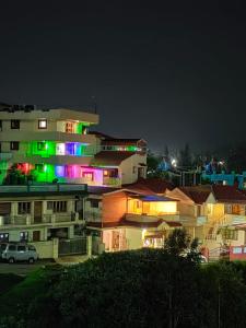 a building with colorful lights on it at night at TRIOS in Ooty