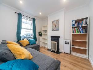 sala de estar con sofá y chimenea en Charming Period Home near Surbiton with Garden, en Londres