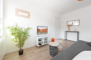 a living room with a couch and a tv at T2 avec parking gratuit - proximité gare in Toulouse