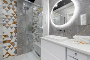 a white bathroom with a sink and a mirror at Modern Apartment With Private Garden Międzywodzie by Renters Prestige in Międzywodzie