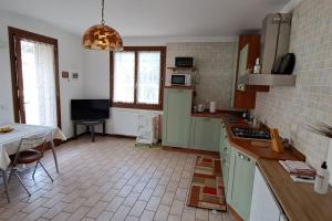 una cocina con armarios verdes y una mesa. en Little apartment in Dolomiti, en Vigo di Cadore