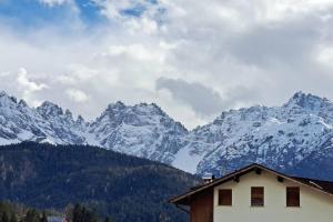 a house in front of a snow covered mountain at Little apartment in Dolomiti in Vigo di Cadore