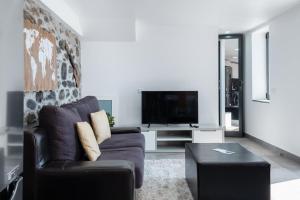 a living room with a couch and a tv at GuestReady - Leme Beach Breathtaking Views in Gaula