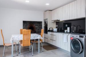 uma cozinha com uma mesa, cadeiras e um fogão em GuestReady - Leme Beach Breathtaking Views em Gaula