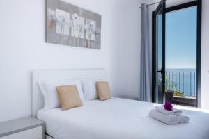 a bedroom with a white bed with a large window at GuestReady - Leme Beach Breathtaking Views in Gaula
