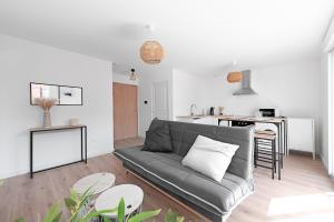 a living room with a couch and a kitchen at T2 avec parking gratuit - proximité gare in Toulouse