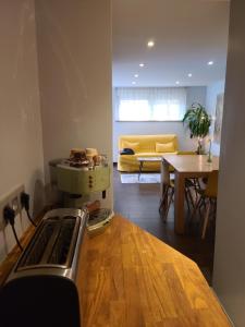 a living room with a table and a yellow couch at DOUX COCON DE 50 m2 PARIS-LE RAINCY in Le Raincy