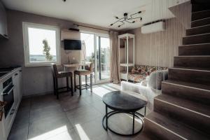 a living room with a staircase and a table and chairs at MY House's - 3 maisons avec piscine commune et la maison pour 3 personnes max avec jacuzzi privé 