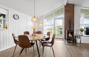 ein Esszimmer mit Tisch und Kamin in der Unterkunft Stunning Home In Hemmet With Wifi in Hemmet