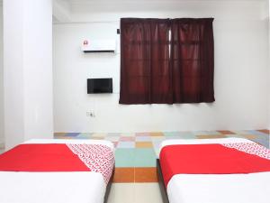 twee bedden in een kamer met een rood gordijn bij KB Rest Inn-Twin Single in Kota Bharu