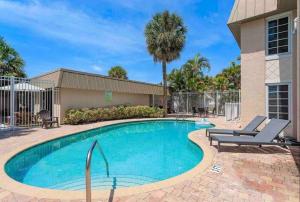 - une piscine avec des chaises longues à côté d'un bâtiment dans l'établissement #1 Beach Siesta Key Village w heated pool & arcade, à Sarasota