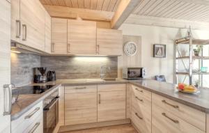 a kitchen with wooden cabinets and a sink at Stunning Home In Dagebüll With Sauna in Dagebüll
