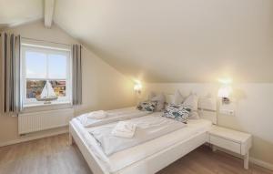 a large white bed in a room with a window at Stunning Home In Dagebüll With Sauna in Dagebüll