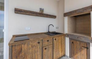 a kitchen with wooden cabinets and a sink at Gorgeous Apartment In Bregi With Sauna in Breza +27 photos