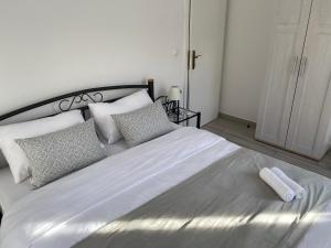 a bedroom with a large white bed with pillows at Riva Apartments Villa Thalia - Milna, Brač in Milna