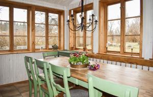 a dining room with a wooden table and chairs at Gorgeous Home In Fjlkinge With House A Panoramic View in Fjälkinge
