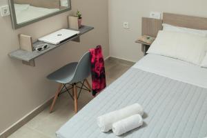 um quarto com uma cama, uma cadeira e um espelho em Stefanie Studios em Agia Marina Nea Kydonias