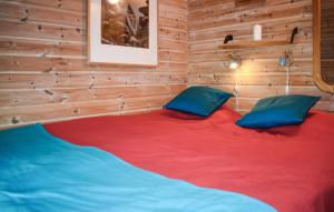 a room with a large red bed with blue pillows at Lovely Apartment In Markaryd With Lake View in Markaryd