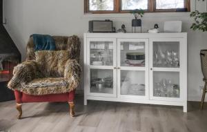 a living room with a chair and a white cabinet at Awesome Home In Norrtälje With Wifi in Vätö